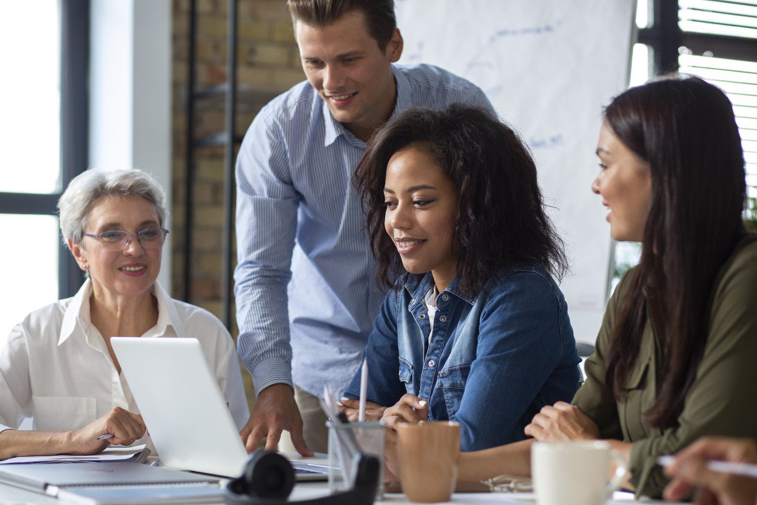 Equipe reunida ao redor de um notebook, clima colaborativo